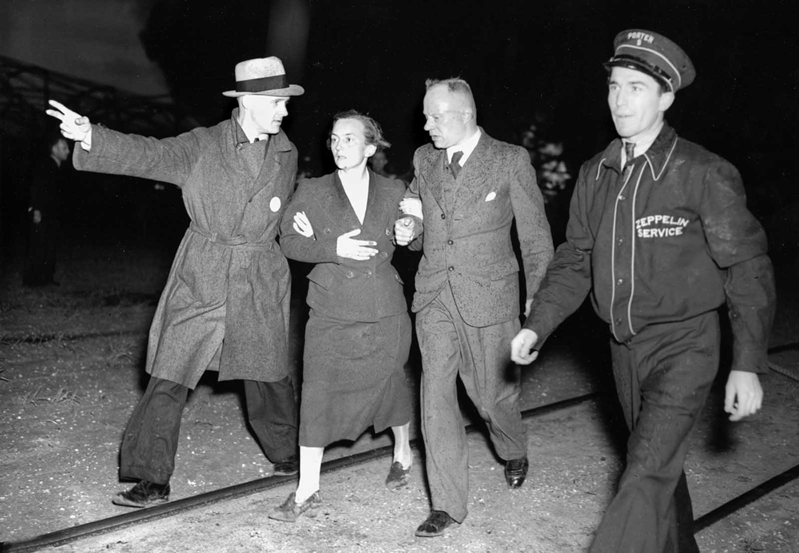 An unidentified woman survivor is led from the scene of the Hindenburg disaster at the U.S. Naval Station in Lakehurst, New Jersey, on May 6, 1937.