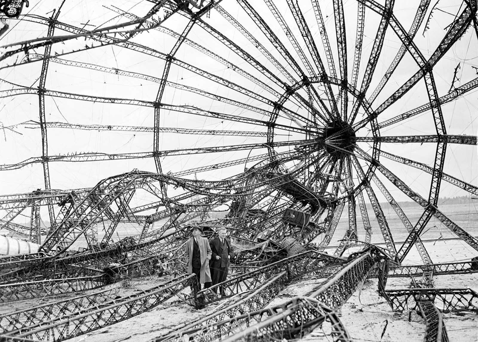Two men inspect the twisted metal framework of the Hindenburg in New Jersey in May of 1937.