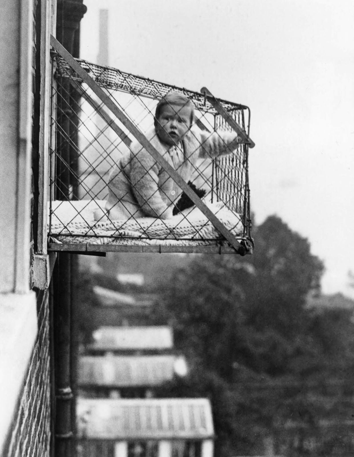 Responding to a lack of homes with outdoor space, people began outfitting windows with infant-sized cages for babies to hang out in. 1934.