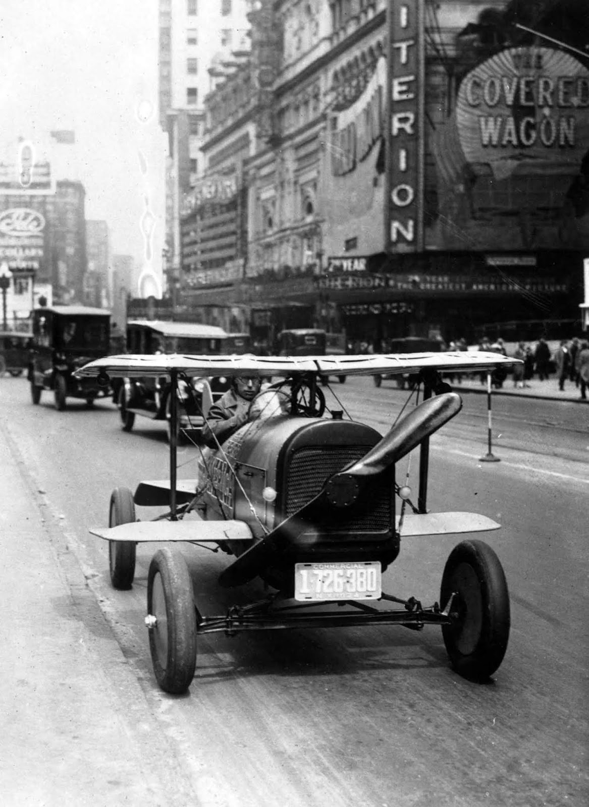 A car with wings and a propeller protruding from the radiator grille drives through Times Square, N.Y. It was the invention of A.H. Russell of Nutley, N.J.