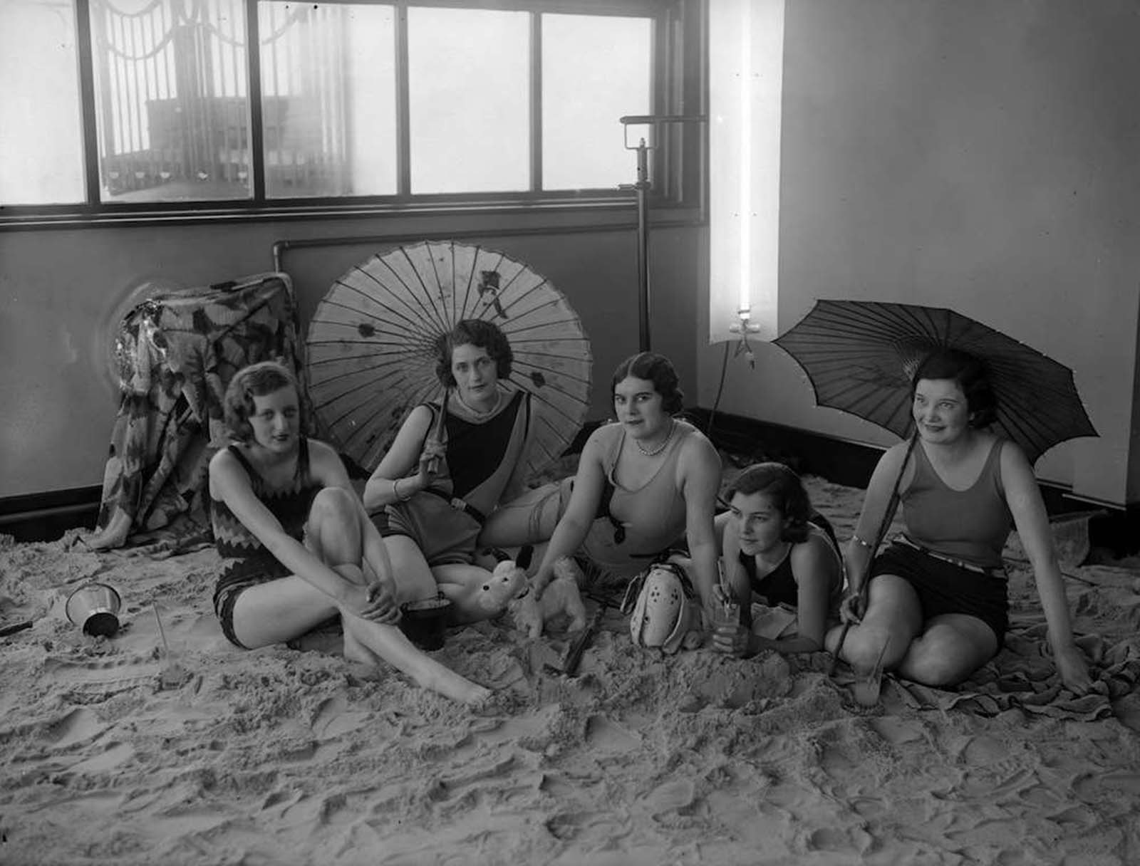 group of ladies relax on the sandy floor in the solarium of the Tolland Hotel, Bournemouth. 1930.