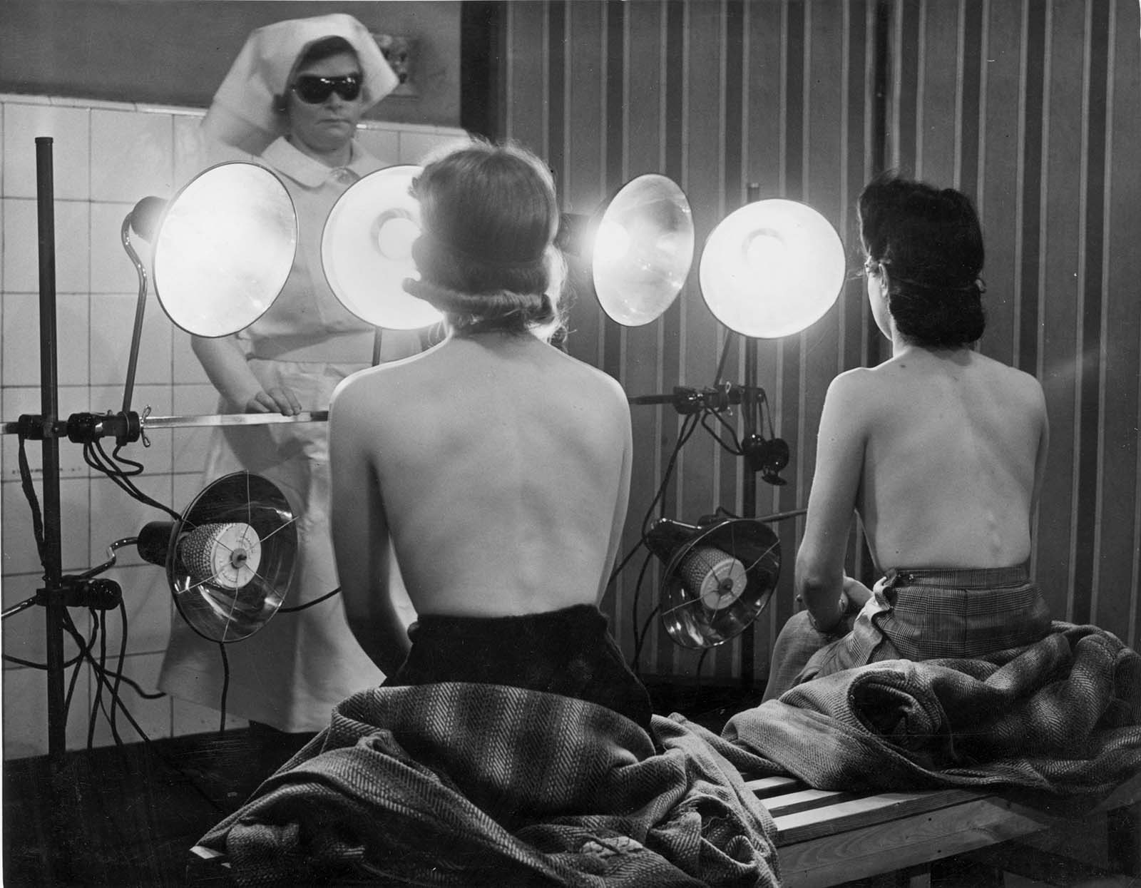 Children from Bermondsey London playing in artificial sunlight in a solarium with a sunlamp providing the ‘sunshine’. 1942.