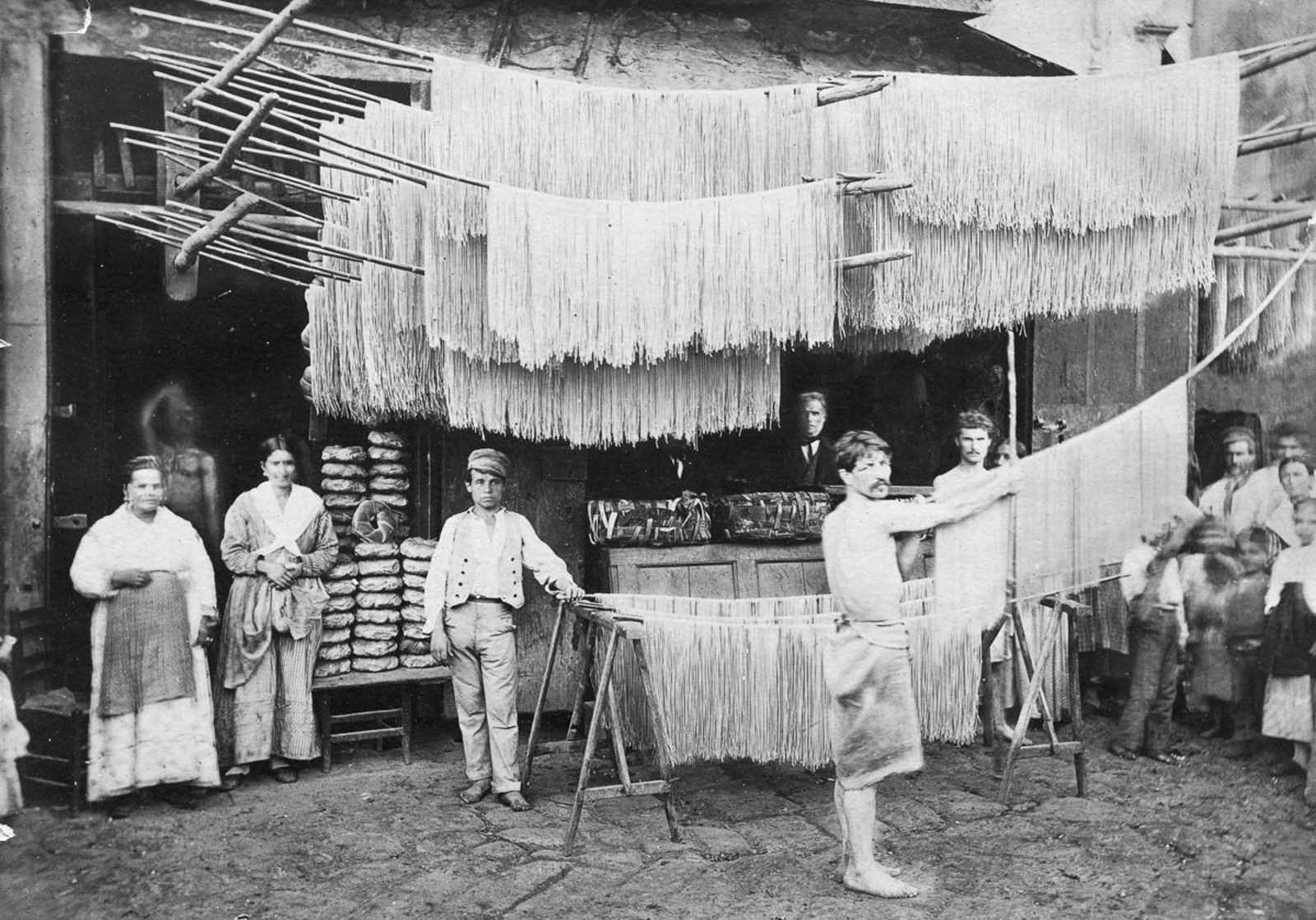 Pasta is hung out to dry in a market. Date unknown.