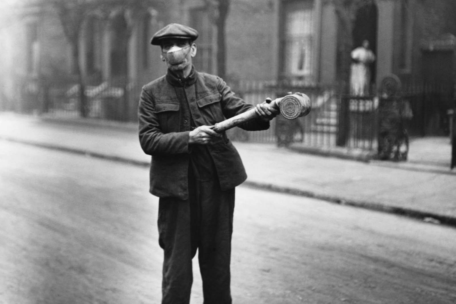 A public health worker carries a spray pump.