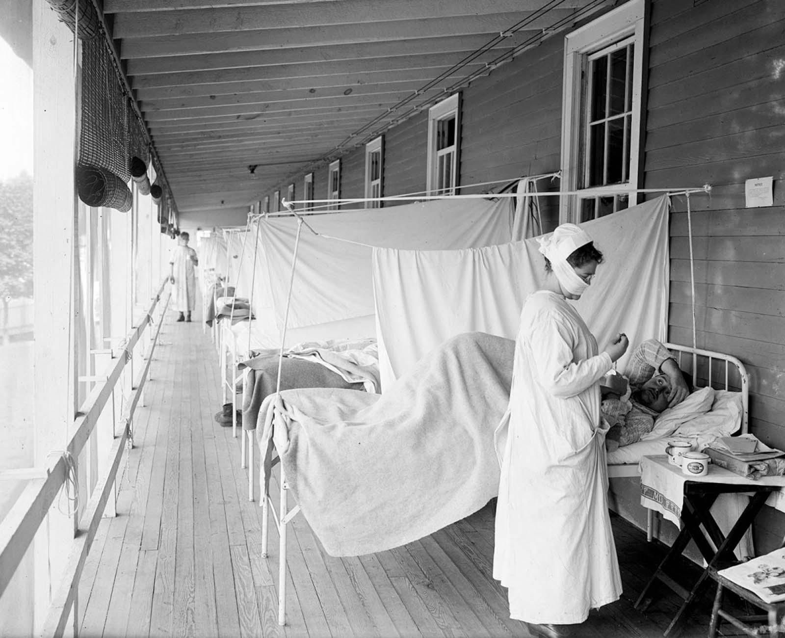 In this November 1918 photo, a nurse takes the pulse of a patient in the influenza ward of the Walter Reed hospital in Washington, D.C.