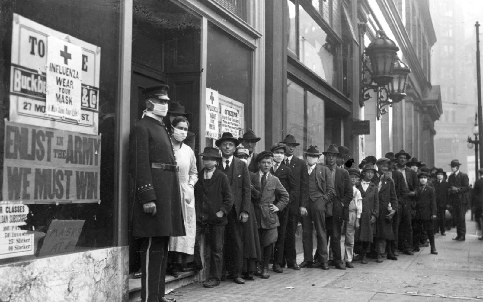eople wait in line to get flu masks on Montgomery Street in San Francisco in 1918.