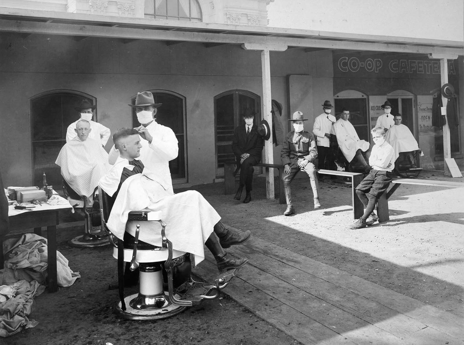 An open-air barber shop serves customers during the epidemic at the University of California, Berkeley, 1919.