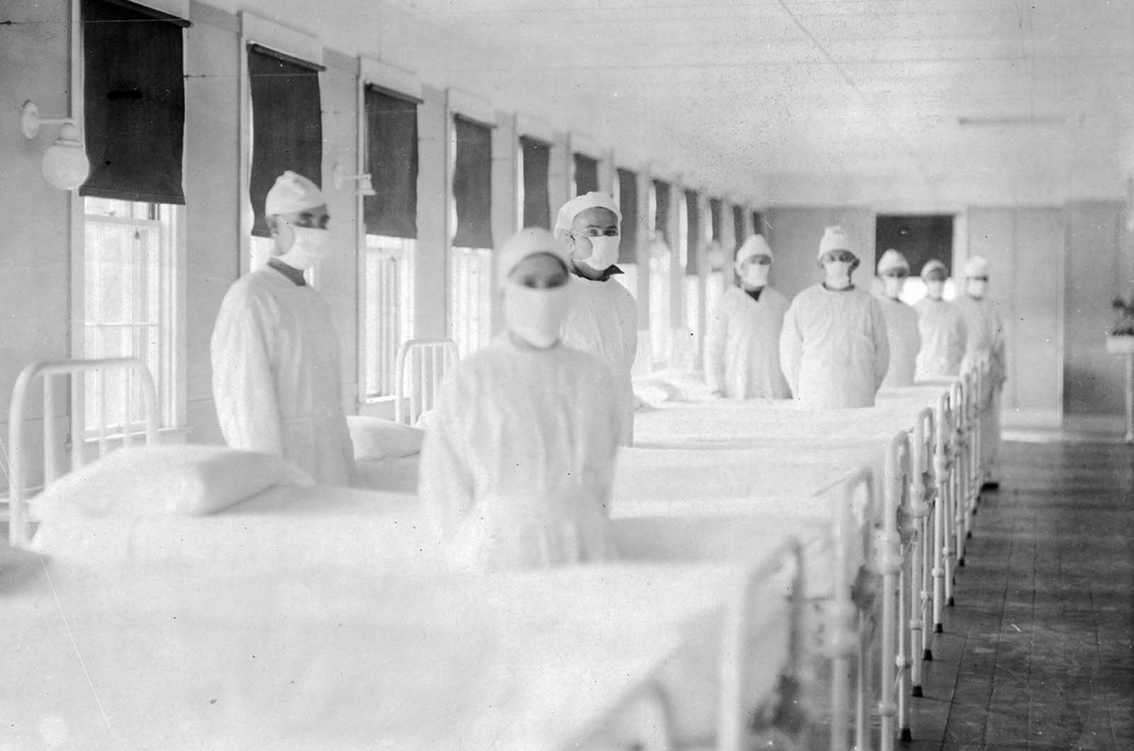 Corpsmen in caps and gowns are ready to attend patients in the influenza ward of a U.S. Navy hospital, in Mare Island, California, on December 10, 1918.