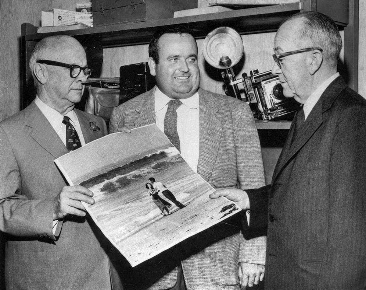 Los Angeles Times photographer Jack Gaunt, center, after winning the Pulitzer Prize, is congratulated by City Editor Bud Lewis, left, and Editor L.D. Hotchkiss.