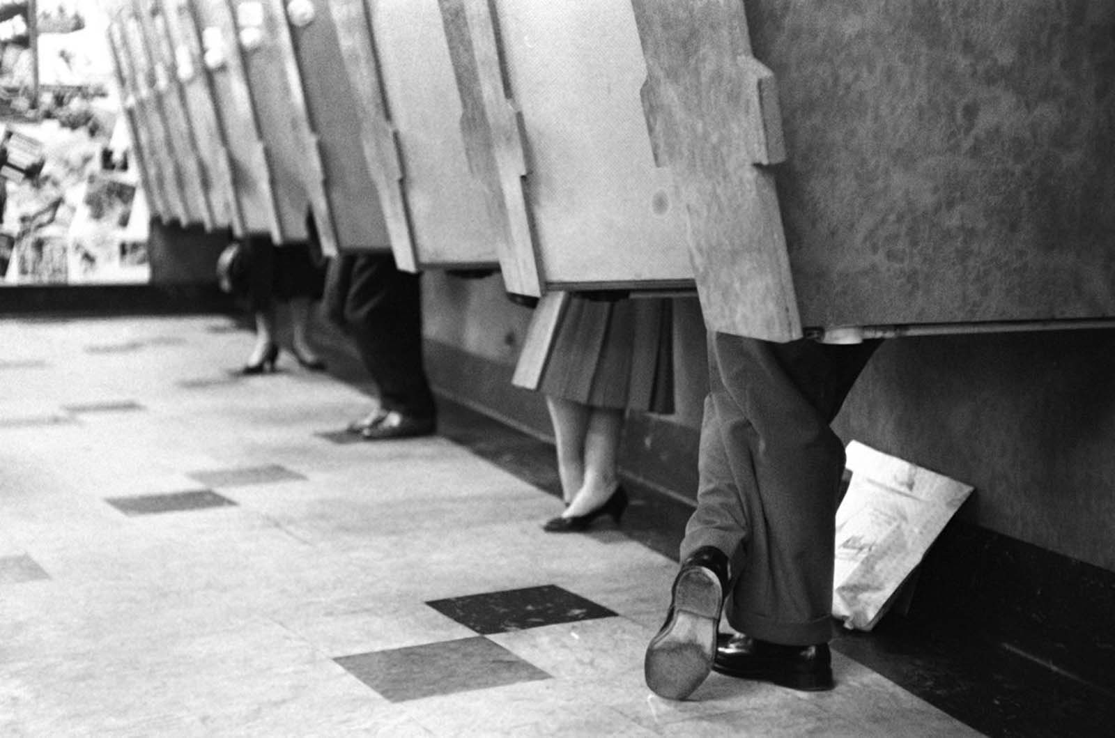 Customers in listening booths while standing up. 1958.