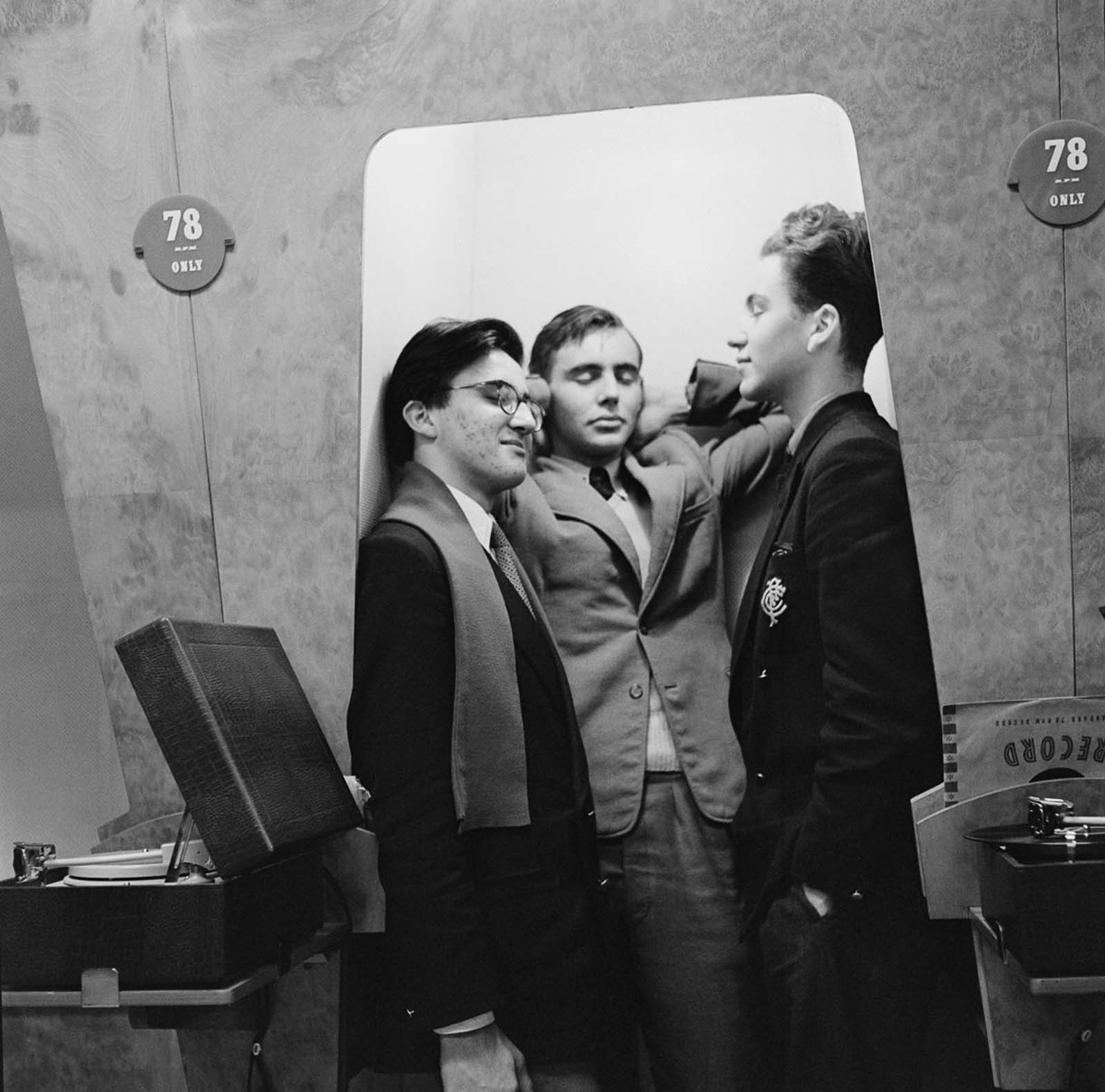 A group of friend enjoying music in a listening booth. 1955.