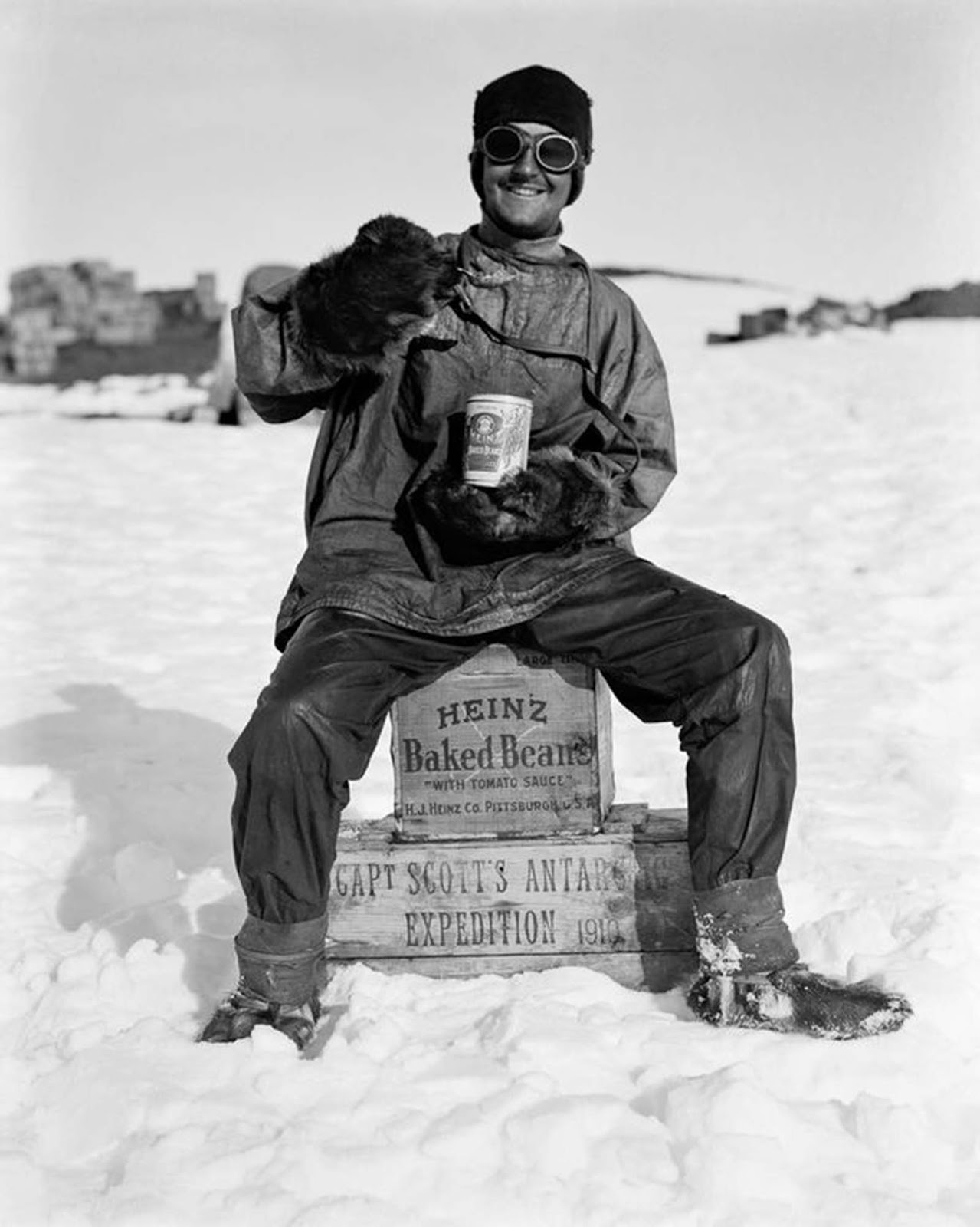 An expedition member enjoys a can of beans at camp. January, 1912.