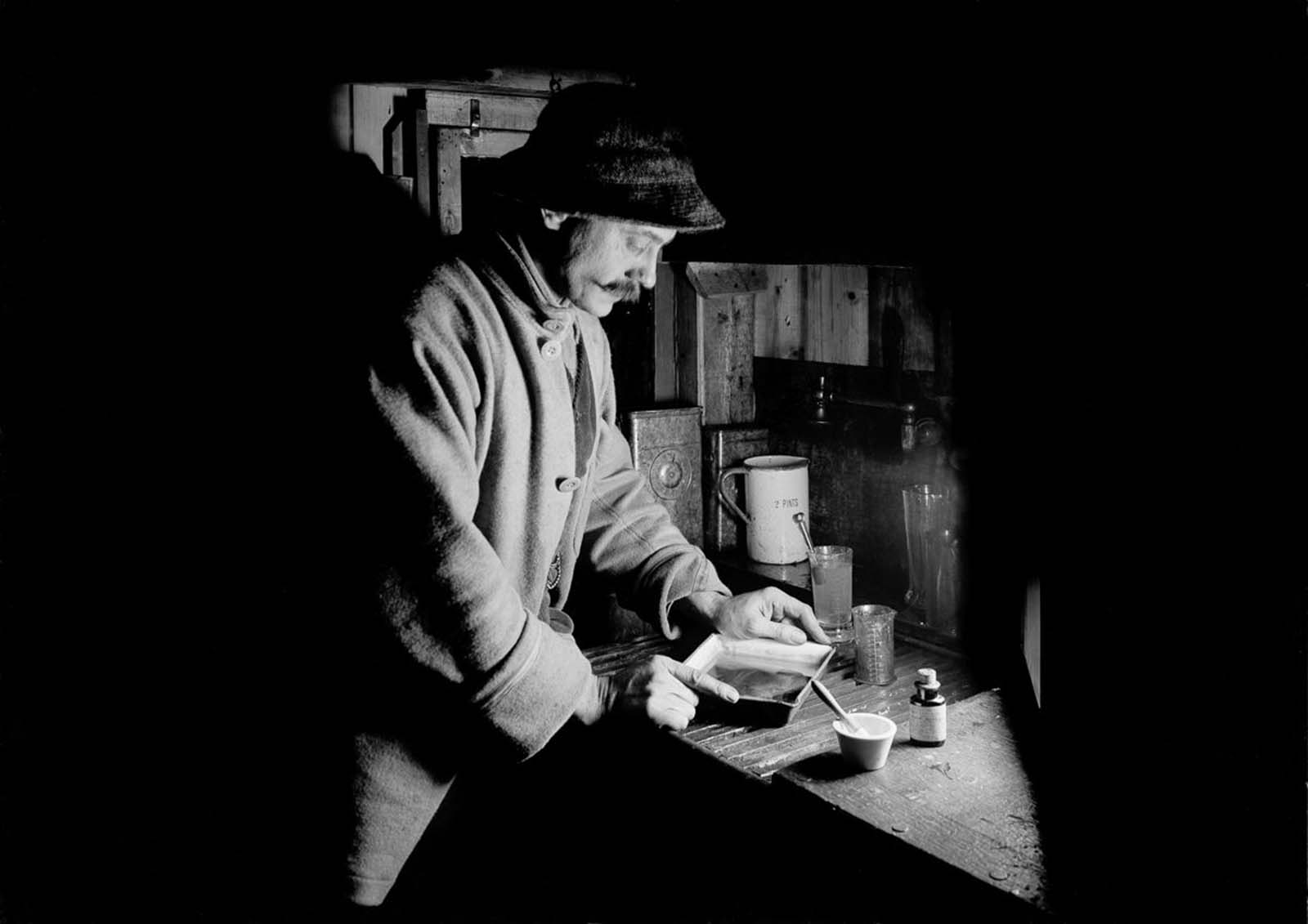 Photographer Herbert Ponting in his makeshift darkroom. July 22, 1911.
