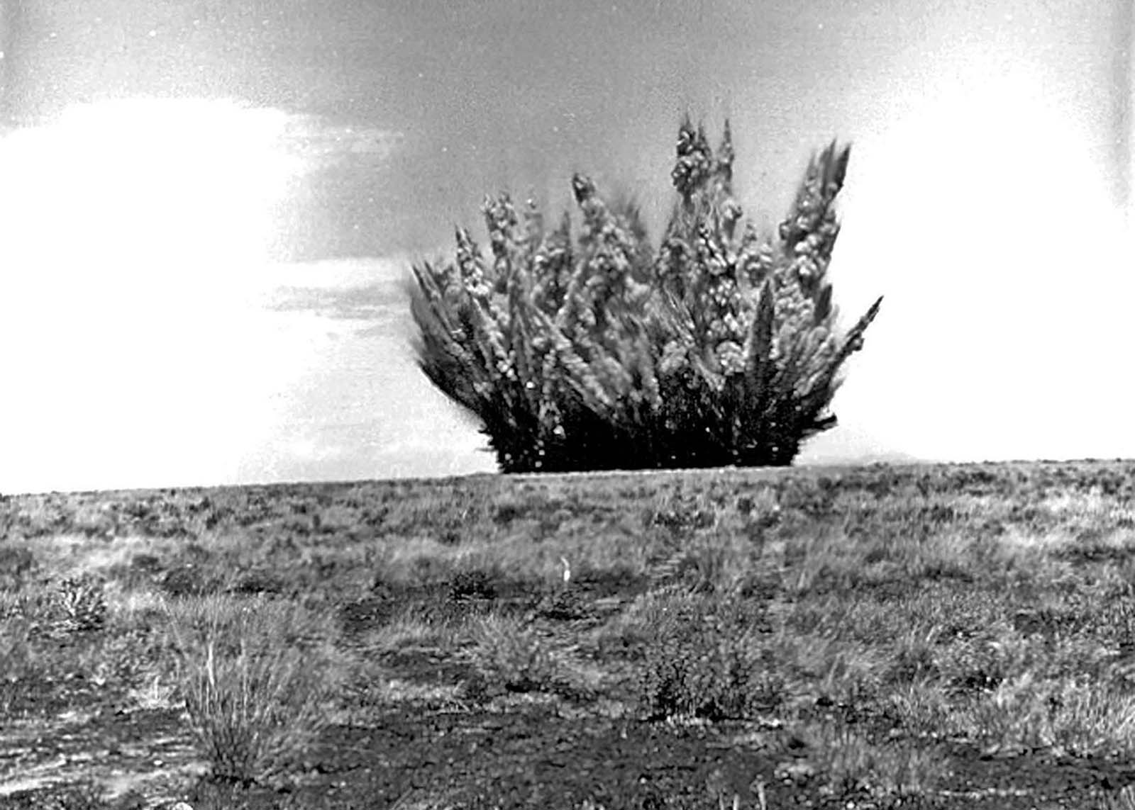 An explosion makes a large test crater on the surface of Black Point lava flow on August 1, 1968, along the Little Colorado River, north of Flagstaff, Arizona.
