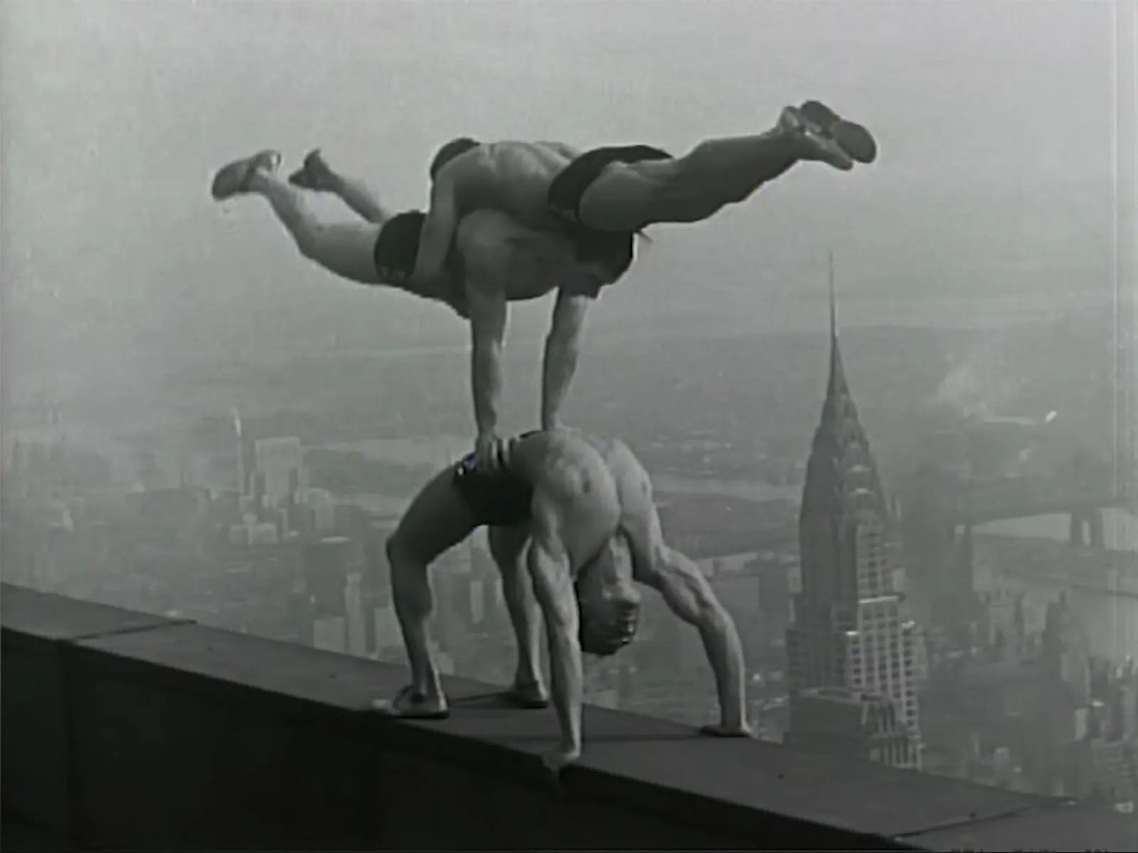 Acrobats balance on top of the Empire State Building