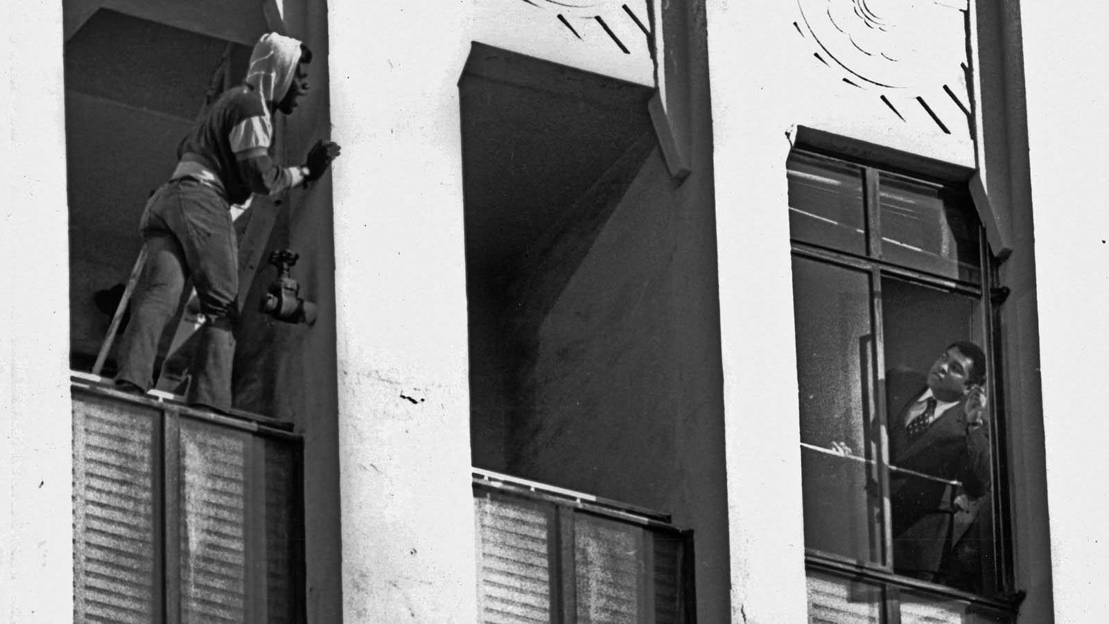 This is the dramatic moment Muhammad Ali saved a suicidal man who was threatening to jump out of a ninth-floor building in Los Angeles in 1981. Ali (right) is seen leaning out of a window pleading with the man.