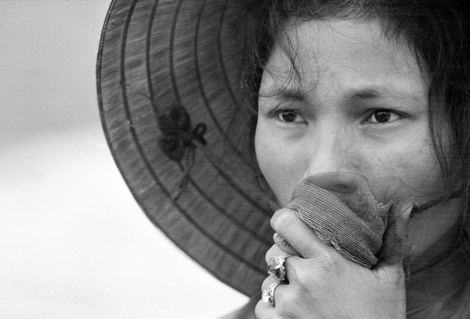 A young South Vietnamese woman covers her mouth as she stares into a mass grave where victims of a reported Viet Cong massacre were being exhumed near Dien Bai village, east of Hue, in April of 1969. The woman's husband, father, and brother had been missing since the Tet Offensive, and were feared to be among those killed by Communist forces.